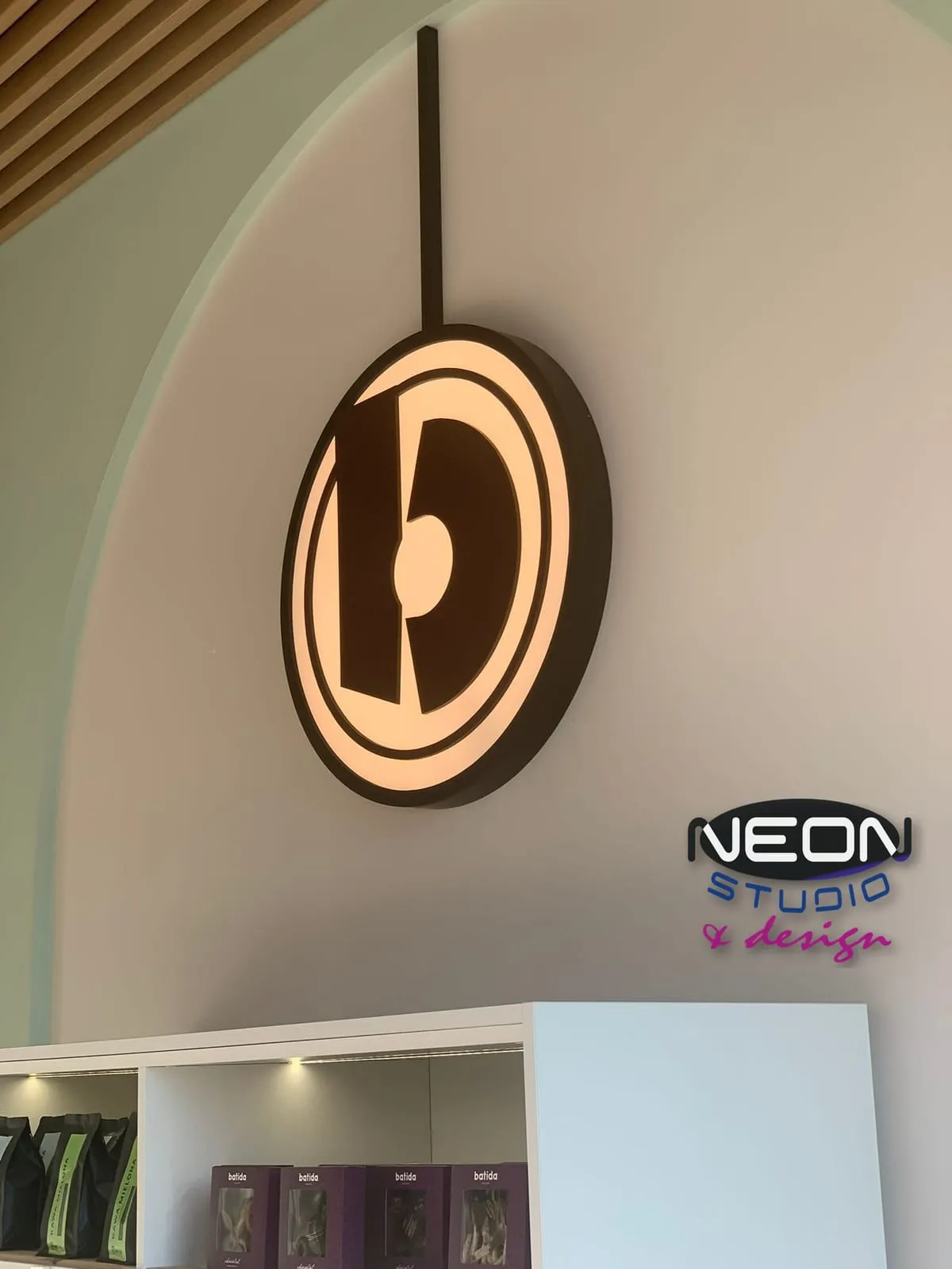 Batida — a round lightbox with the brand's old logo, suspended on a rod inside the venue
