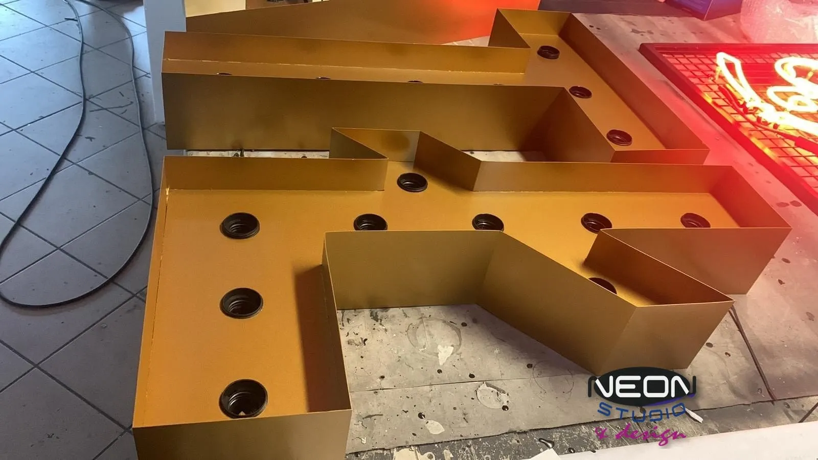 Bulb letters in production — the housing with sockets, before the bulbs go in